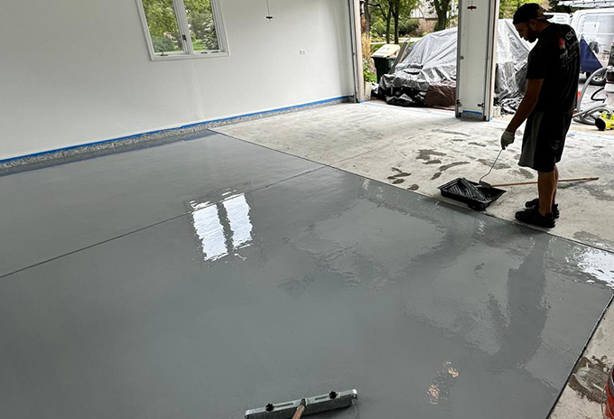 man working on a new garage floor epoxy