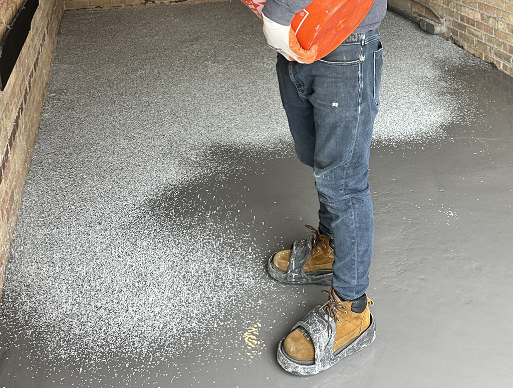 man applying epoxy to garage floor