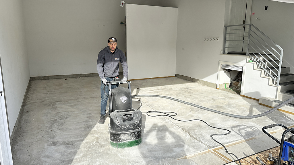 man griding garage floor to prepare for coating